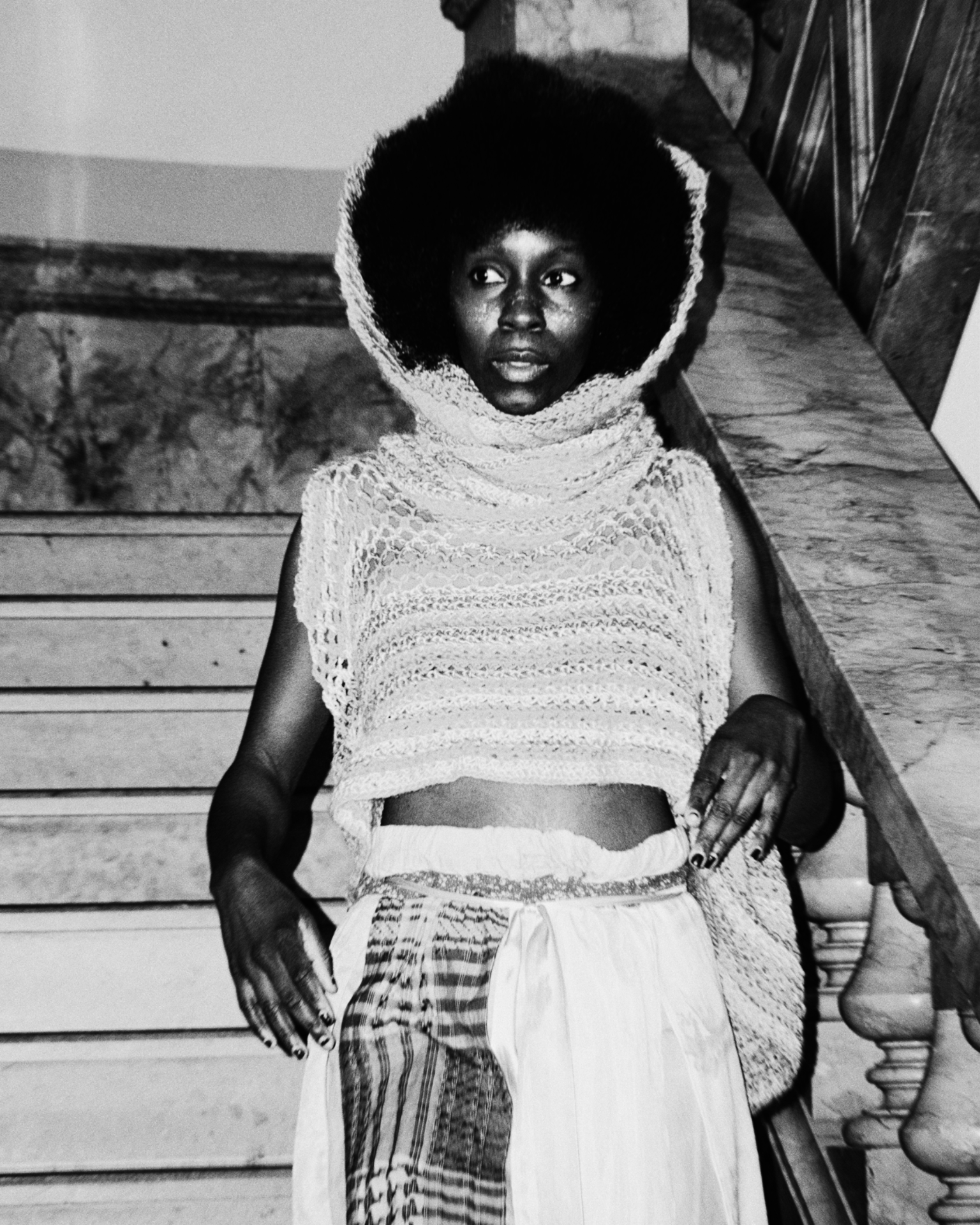 Portrait with afro and knit hood on staircase