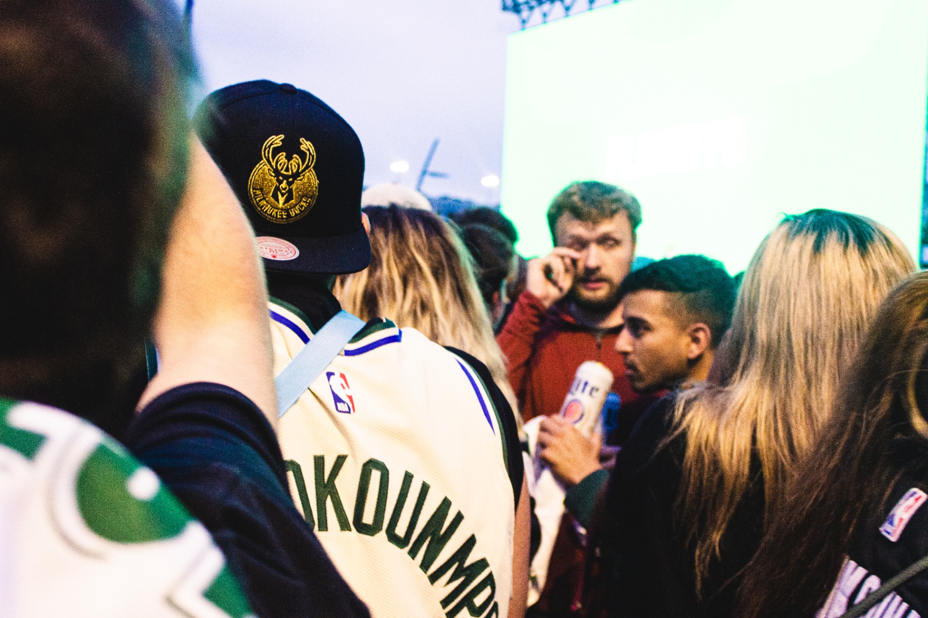 Fans in throwback Bucks gear crowded near screens