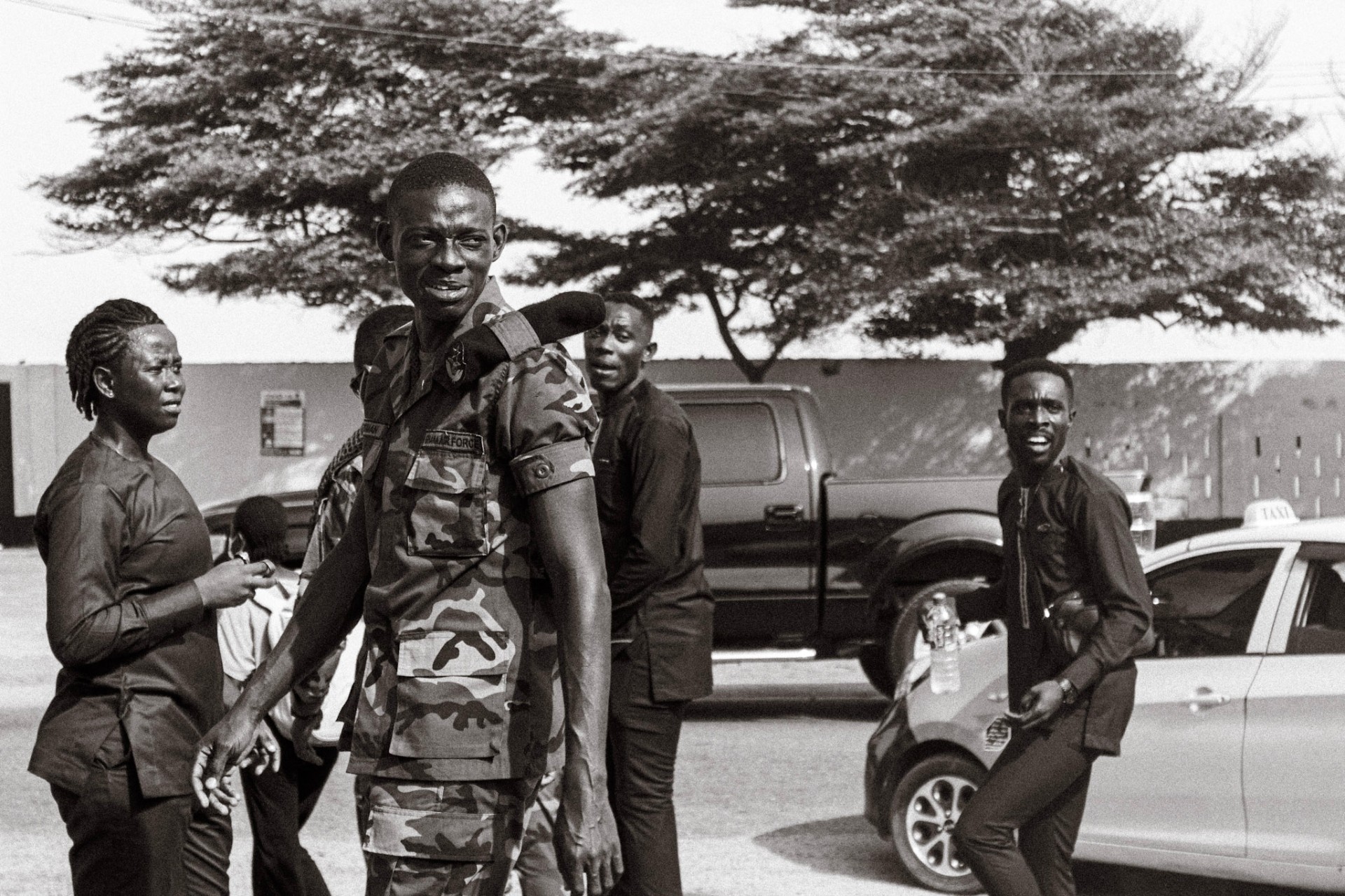 Young man in Ghana Air Force fatigues among friends