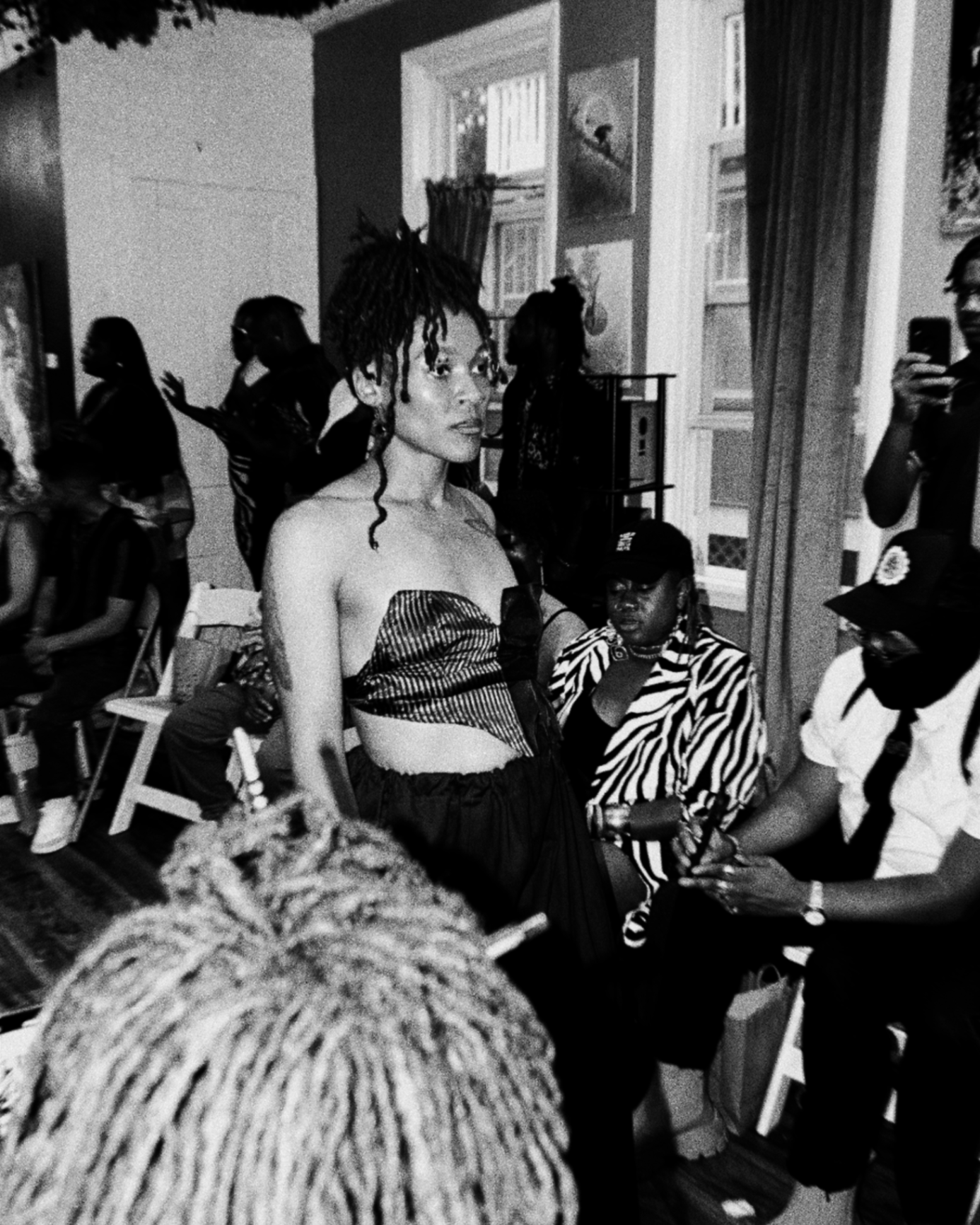 Indoor fashion event with audience gathered around model