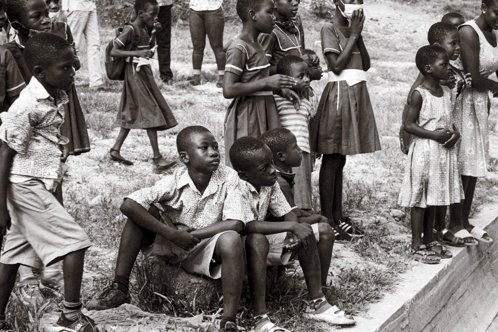 Ghanaian schoolchildren gathered in uniforms outside a school