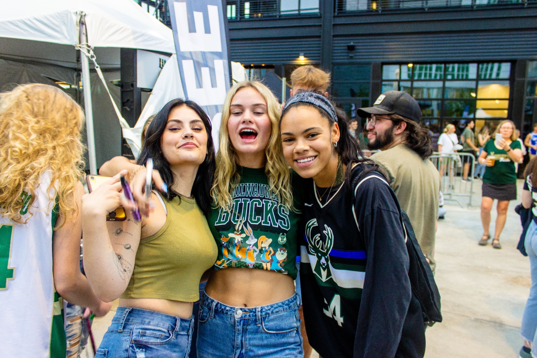 Three fans posing at a Bucks watch party in Deer District