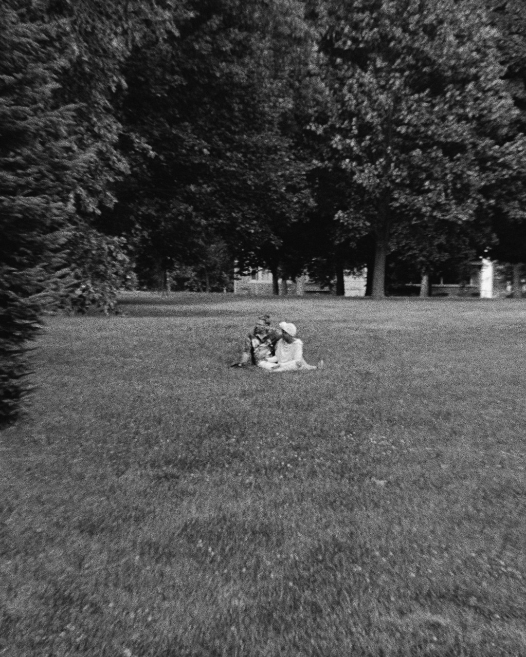 Two people sitting together in a large park