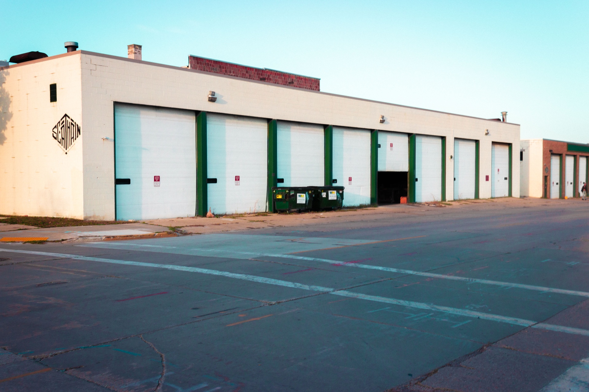 Row of white loading dock doors on a Milwaukee warehouse at sunset