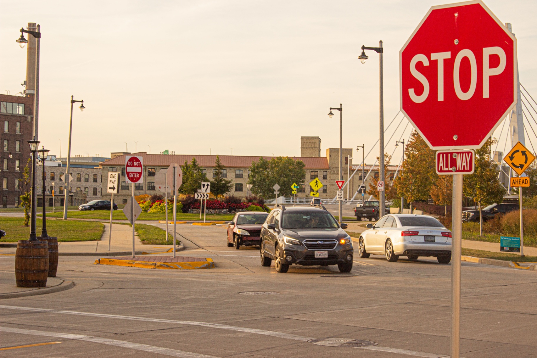 STOP all-way sign at a roundabout with the 6th Street Bridge behind