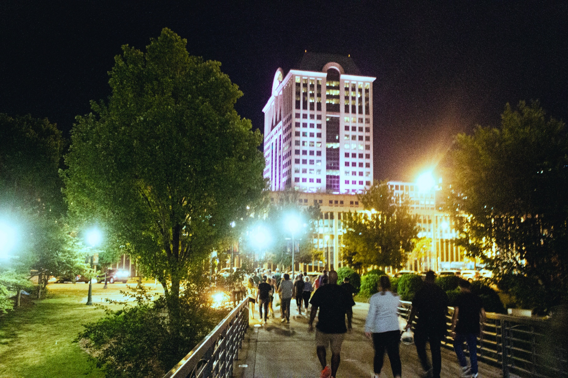 Crowd walking toward the US Bank tower at night
