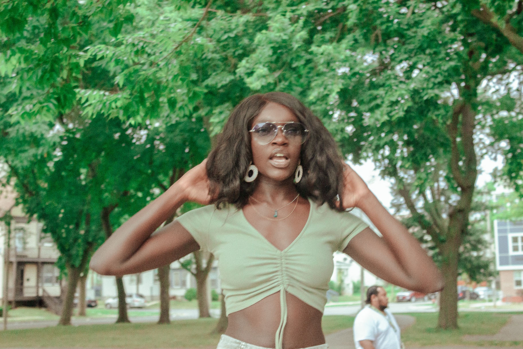 Woman lifting her hair with both hands in a Milwaukee park